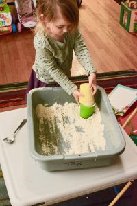 Playing with moon sand and cups